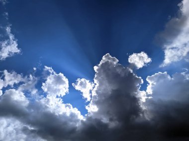 Güneş ışınları bulutların altından doğuyor.