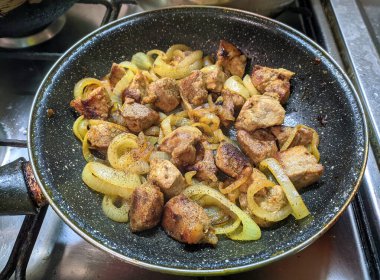 Tavada soğanlı kızarmış domuz eti.