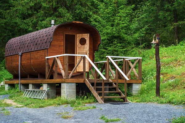 Tahta kırsal hamam, Karelia 'da bir ormanın arka planına karşı bir fıçı gibi şekillendirildi..