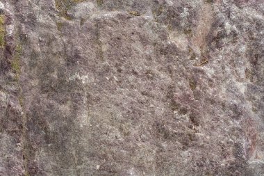 Soyut bir arkaplan ve doku olarak kullanılmak üzere gri-pembe taşın pürüzlü yüzeyi.