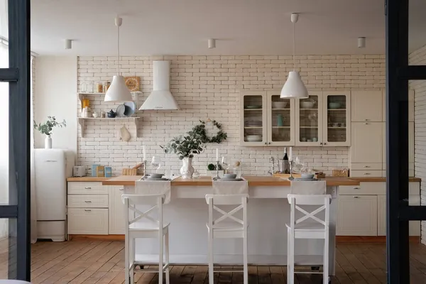Modern stil beyaz ve hafif ahşap İskandinav mutfağının içi mutfak aksesuarlarıyla dolu..