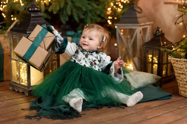 Smiling girl with present gift box sitting near stylish decorated Christmas tree. — Stock Photo, Image