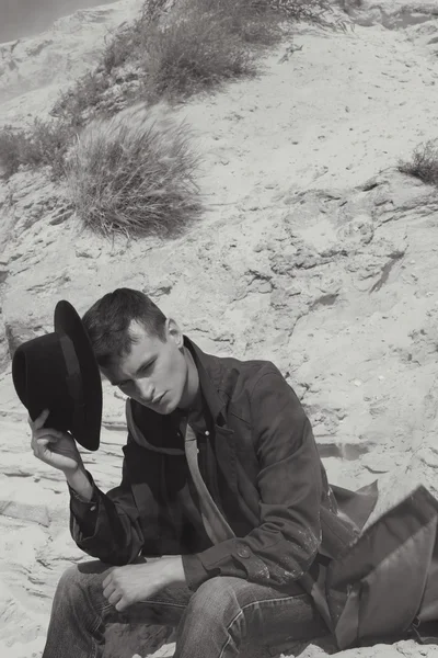 Klasik takım elbiseli güzel acımasız adam. nehir suyu yakınlarında çölde kovboy. moda ve güzellik. siyah-beyaz doğa