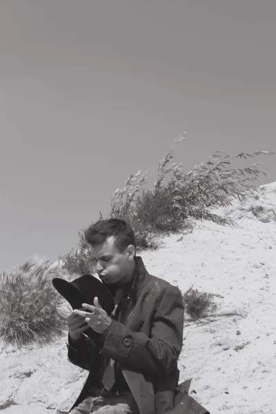 Klasik takım elbiseli güzel acımasız adam. nehir suyu yakınlarında çölde kovboy. moda ve güzellik. siyah-beyaz doğa