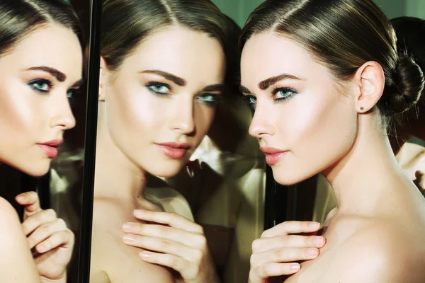 Bella e bella ragazza dell'aspetto europeo pelle pulita e sana con trucco marrone e occhi verdi nel riflesso sullo sfondo dello specchio. Moda e bellezza . — Foto Stock