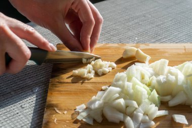 Woman cutting garlic and onion with knife