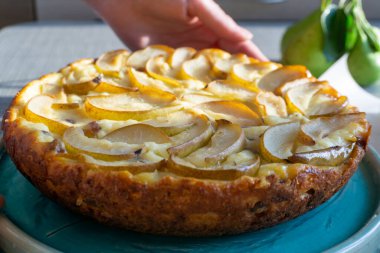 Casserole pie of cottage cheese with raisins and pears. Woman hands