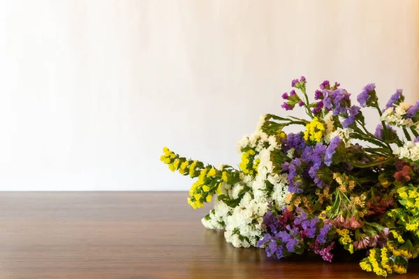 Colorful bouquet of dried flowers on the wooden table. Front view. Copy space. White background