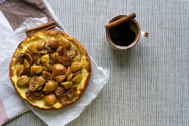 Üzümlü süzme peynirli güveç ve üstüne karamelli armut, yanında da bir fincan sade kahve. Görünümün üstünde