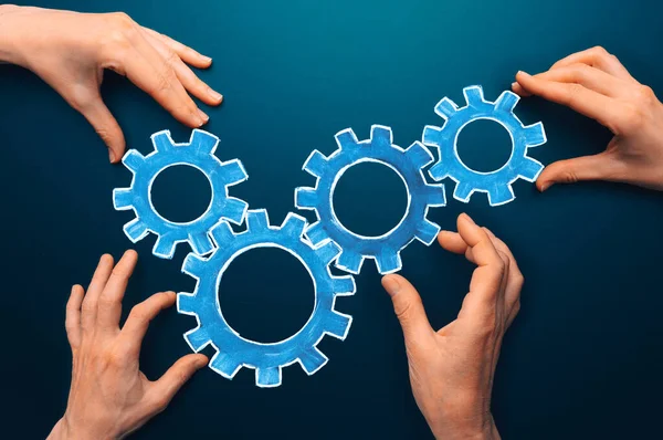 Teamwork concept. team connects gear parts. Idea of partnership, cooperation, team work. Metaphor for joining a partnership as diverse gears connected together as a corporate symbol for cooperation