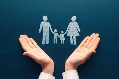 Family life care insurance concept. Female tender hands with a family symbol drawing on chalkboard. Protecting the rights of people and minorities. Love for the children idea