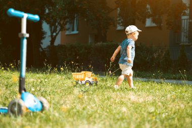 Çocuklar dışarıda oyuncak kamyonla oynuyorlar. Çocuklar için açık havada yaratıcı aktiviteler. Yaz ve çocukluk kavramı