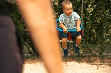 Büyükanne ve çocuk birlikte eğleniyor, salıncakta oynuyorlar. Nesil ve çocukluk kavramı. Mutlu aile sembolü