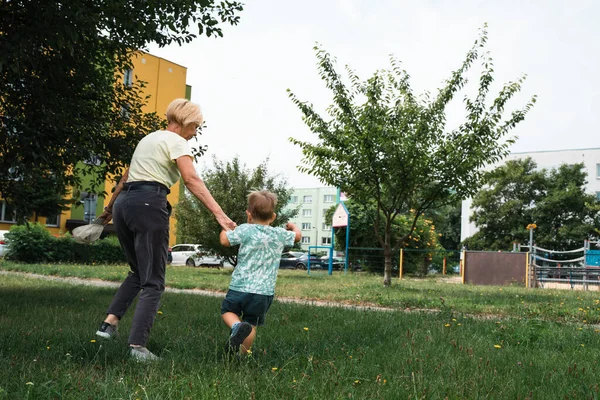Grandmother and child running in kindergarten. Happy family idea. Generation, happiness vitality concept.