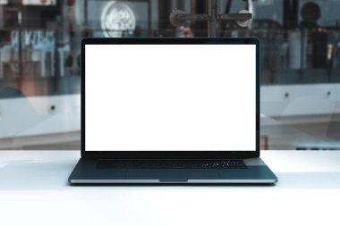 Laptop mockup with white screen in business office or shopping mall. Empty copy space, blank screen mockup. Soft focus laptop with interor background. Travel, study and office work concept.