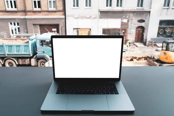 laptop mockup. Notebook with white screen with construction background. Urban, and remote work and study concept. Empty copy space, blank screen modern laptop