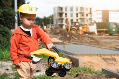 İnşaat alanı yakınında kazı yapan bir çocuk, mühendis olmayı hayal ediyor. Küçük inşaatçı. Eğitim, hayal gücü, amaç kavramı..