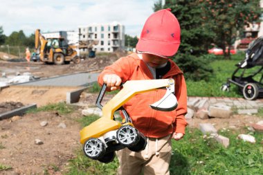 İnşaat alanı yakınında kazı yapan bir çocuk, mühendis olmayı hayal ediyor. Küçük inşaatçı. Eğitim, hayal gücü, amaç kavramı..