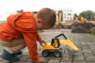 İnşaat alanı yakınında kazı yapan bir çocuk, mühendis olmayı hayal ediyor. Küçük inşaatçı. Eğitim, hayal gücü, amaç kavramı..