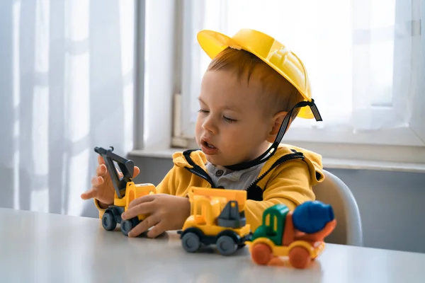 Child play with construction machinery at home, dreams to be an engineer. Little builder. Education, and imagination, purposefulness concept. Boy with digger.