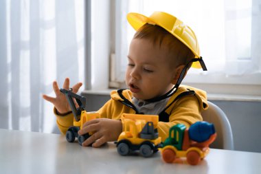 Evde inşaat makineleriyle oynayan çocuklar, mühendis olma hayalleri. Küçük inşaatçı. Eğitim, hayal gücü, amaç kavramı. Kazıcılı çocuk.