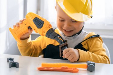 Evde iş aletleriyle oynayan çocuklar, mühendis olma hayalleri. Küçük inşaatçı çocuk. Eğitim, hayal gücü, amaç kavramı. Çocuk ve talim.