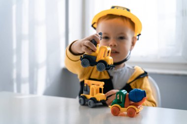 Evde inşaat makineleriyle oynayan çocuklar, mühendis olma hayalleri. Küçük inşaatçı. Eğitim, hayal gücü, amaç kavramı. Kazıcılı çocuk.