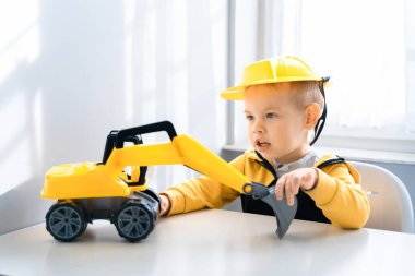 Evde kazıcıyla oynayan çocuklar, mühendis olma hayalleri. Küçük inşaatçı. Eğitim, hayal gücü, amaç kavramı. Kazıcılı çocuk.