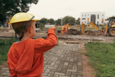 İnşaat alanı yakınında kazı yapan bir çocuk, mühendis olmayı hayal ediyor. Küçük inşaatçı. Eğitim, hayal gücü, amaç kavramı..