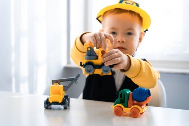 Evde inşaat makineleriyle oynayan çocuklar, mühendis olma hayalleri. Küçük inşaatçı. Eğitim, hayal gücü, amaç kavramı. Kazıcılı çocuk.