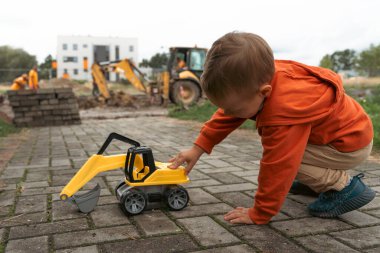 İnşaat alanı yakınında kazı yapan bir çocuk, mühendis olmayı hayal ediyor. Küçük inşaatçı. Eğitim, hayal gücü, amaç kavramı..