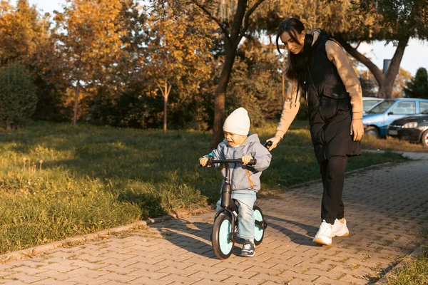 Feliz Madre Familia Enseña Hijo Montar Bicicleta Parque Chico Llorón —  Fotos de Stock