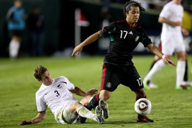 giovani dos santos tony lochhead maç sırasında topun sahibi korumak için kapalı tutar.