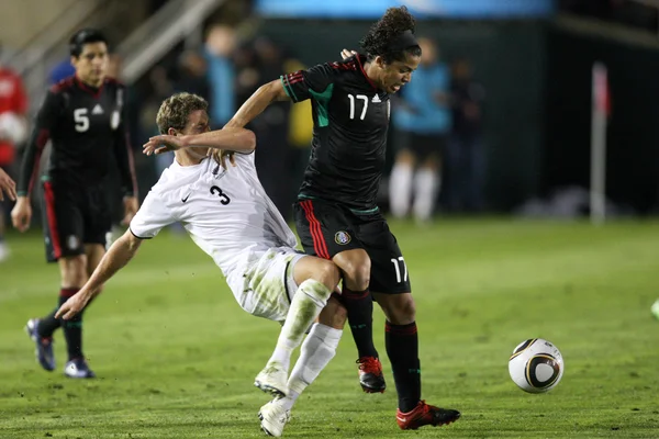 Giovani dos santos innehar av tony lochhead att upprätthålla besittning av bollen under matchen — Stockfoto