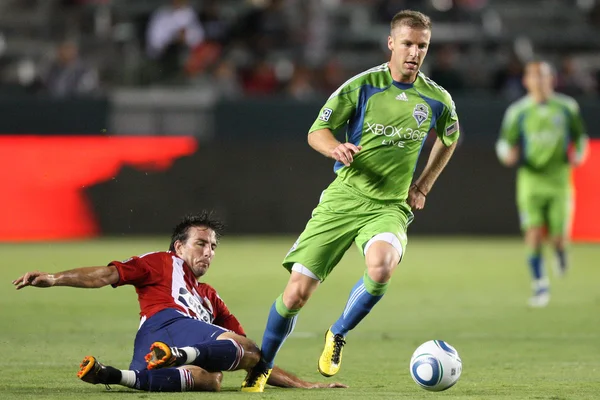 Jeff Parke gets past a slide tackle by Alan Gordon during the game — Stock Photo, Image