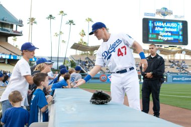 Jerry Sands signs autographs for young fans before the game clipart