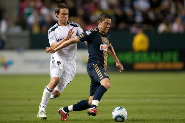 Todd Dunivant chases down Kyle Nakazawa during the game — Stock Photo, Image