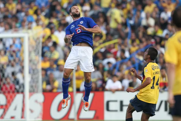 Emanuel Villa jumps to get a head on teh ball gets a head on the ball while Club America Armando Sanchez watches during the game — Stock Photo, Image