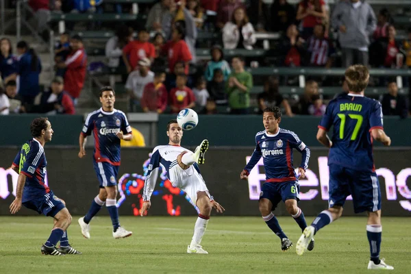 Бенни Фейлхабер контролирует мяч в окружении игроков Chivas USA во время игры — стоковое фото