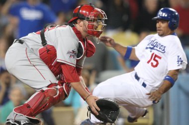 Bobby Wilson waits for the throw to home while Rafael Furcal slides in and scores during the game clipart
