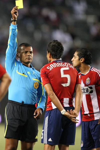 Yader Reyes donne un carton jaune à Marcelo Saragosa pendant que Mariano Trujillo regarde pendant le match — Photo