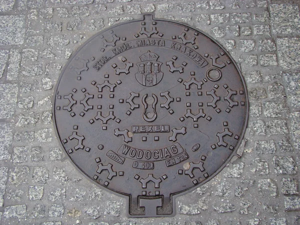 Cracóvia. Manhole na rua pedonal — Fotografia de Stock