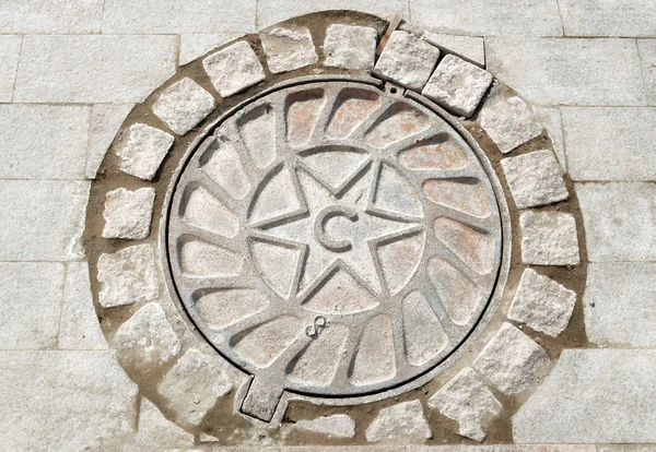 Manhole cover with the image of star — Stock Photo, Image