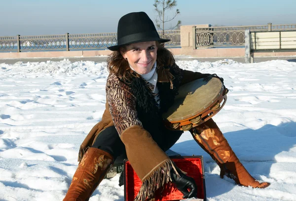 Milá dívka v klobouku s tamburína v zimě na město irkutsk nábřeží — Stock fotografie