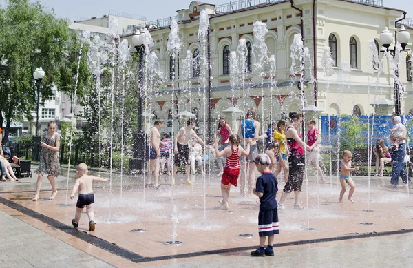 As crianças correm em jatos da nova fonte na rua do centro da cidade em Irkutsk, Rússia — Fotografia de Stock