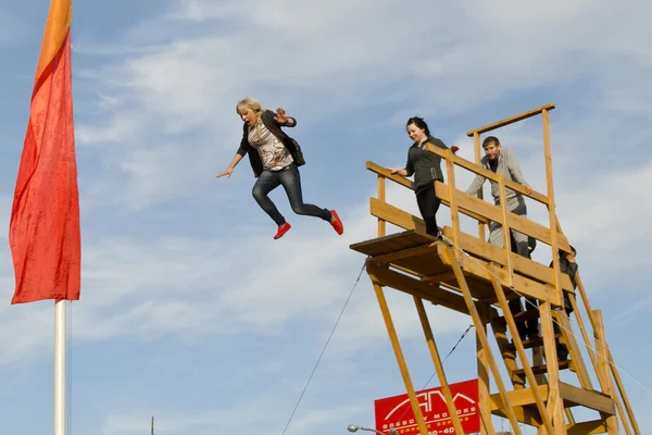 アトラクション。女の子、インフレータブル枕の上に塔からジャンプします。イルクーツク — ストック写真