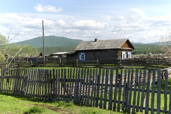 Unpainted wooden house and a fence. Buryat village. — Stock Photo, Image