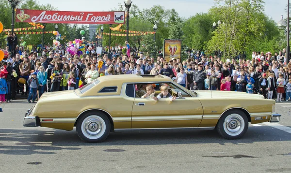 De parade op de straten van Irkoetsk ter ere van de stad dag. Gouden uitvoerende klasse auto. Zijaanzicht. — Stockfoto