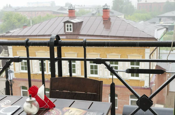 Mesa vacía y húmeda en un café al aire libre durante una tormenta —  Fotos de Stock