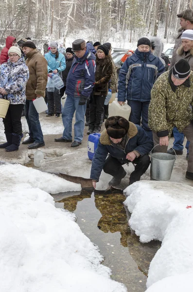 Mensen nemen water in de Heilige goed lente op epiphany-dag. Irkutsk regio, Rusland — Stockfoto